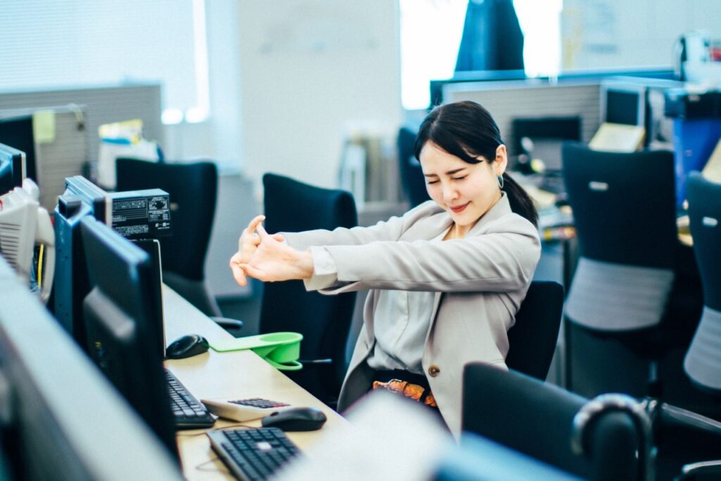 デスクワークでストレッチする女性